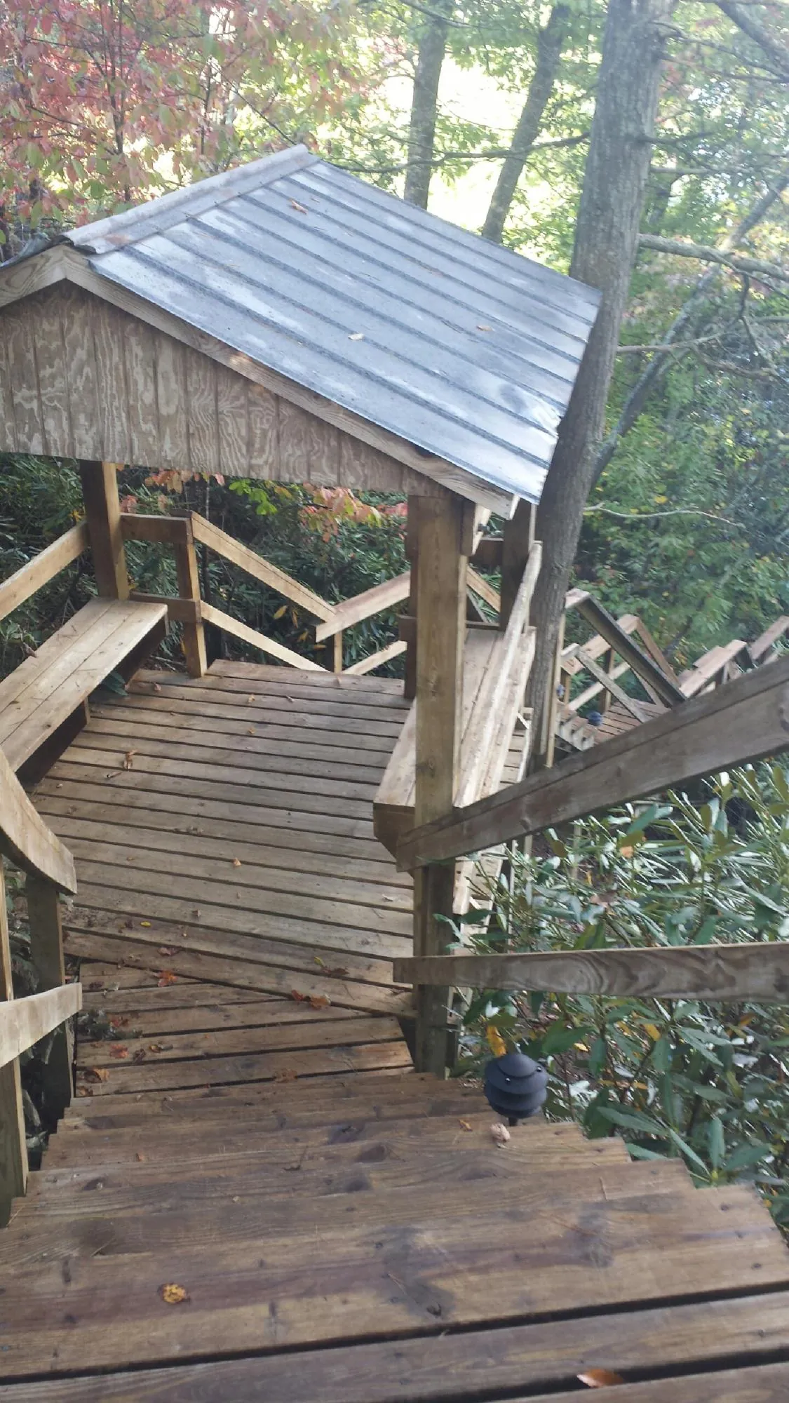 Metal roofed shelter over wooden steps on a wooded walkway — Skylight Repair & Installation work by our crew in Circleville